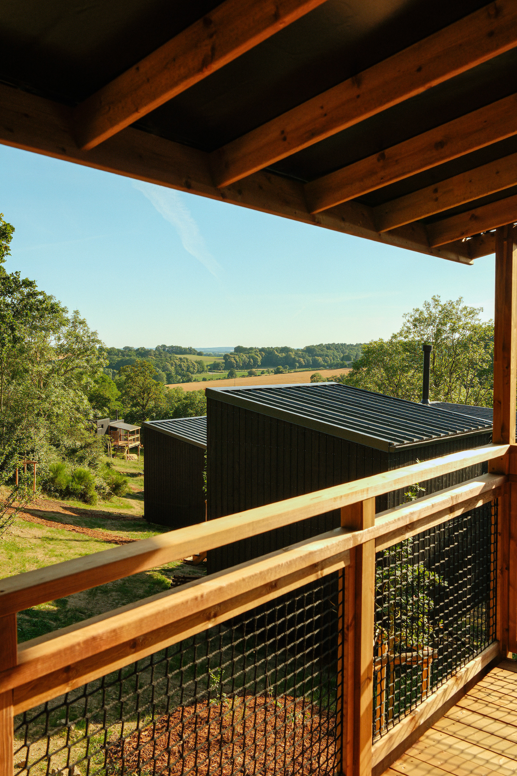 Vue sur les cabanes et la vallée depuis une terrasse au Bon Air Club à Saint-Léonard-des-Bois