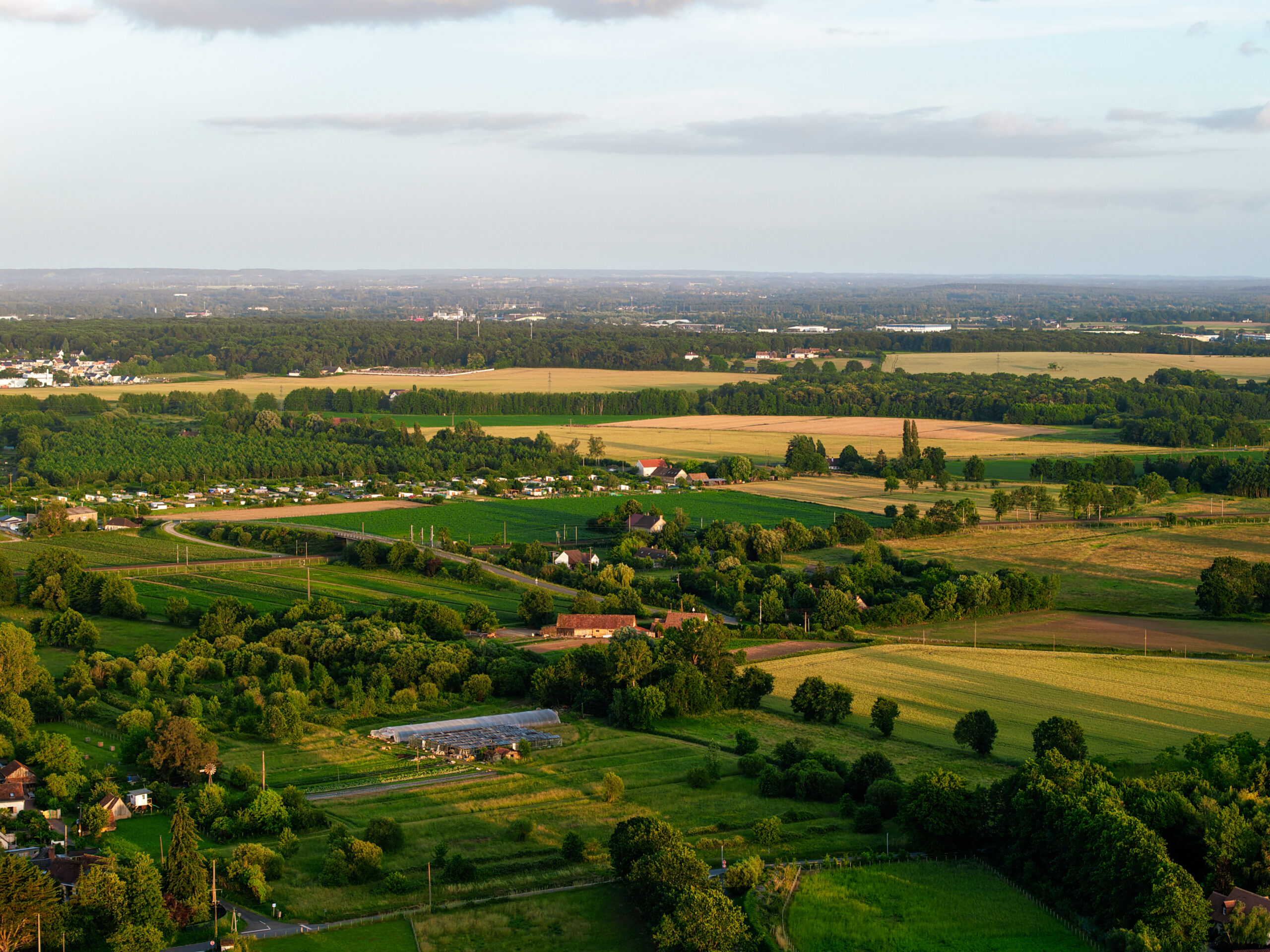 Vue aérienne par drone d’une campagne avec champs et bois en Sarthe